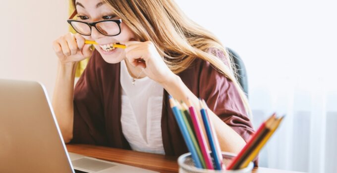 student biting pencil