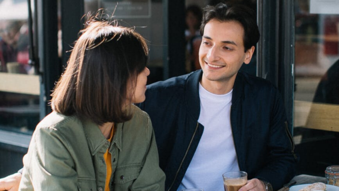 A man talking to a woman on the bench