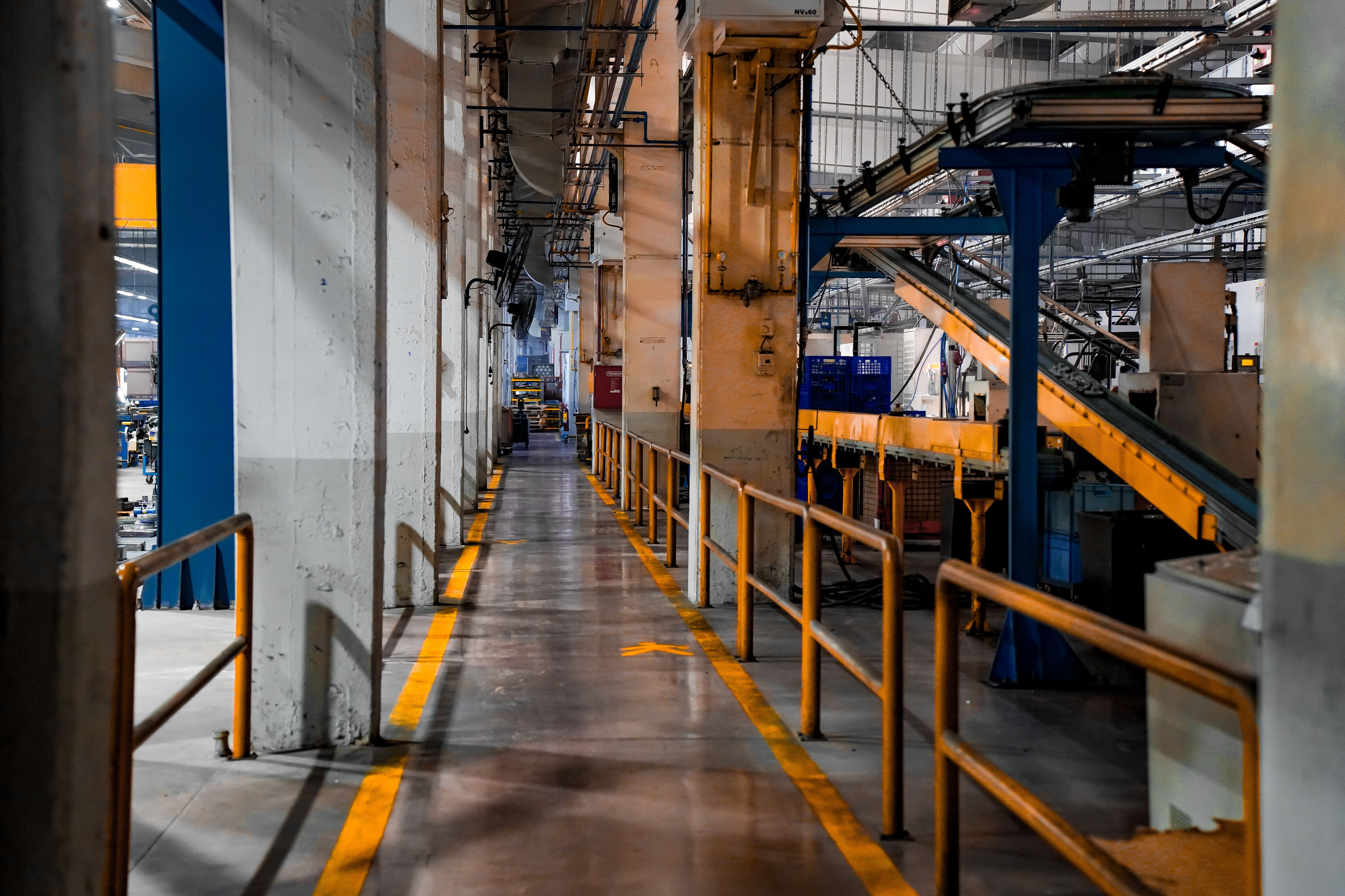 Wide view of a modern factory interior with industrial machinery and conveyor systems for large-scale production