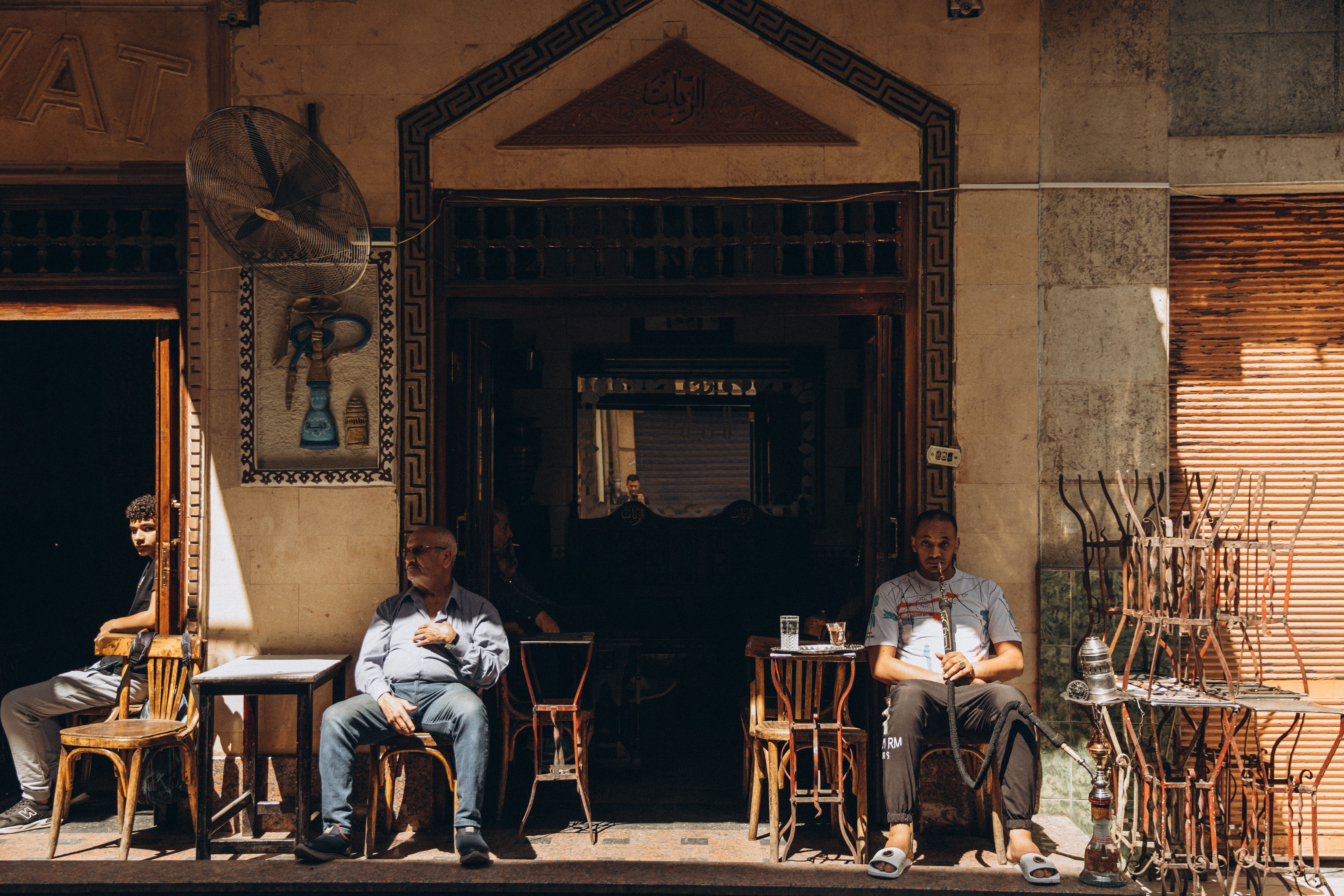 A vibrant scene at a traditional Cairo café with locals enjoying a sunny day.